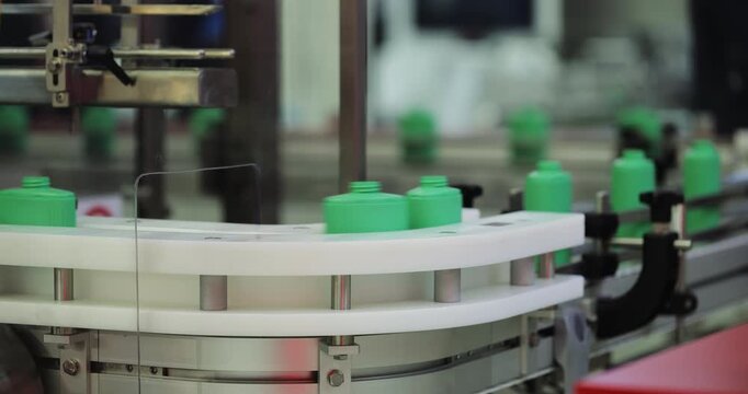 Modern factory equipment processes green plastic bottles for consumer packaging. Automated systems streamline production and improve productivity at plant