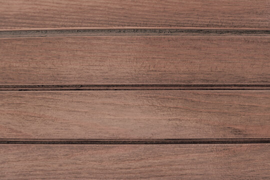 Full frame texture of horizontal brown wooden planks with fine grain and dark seams suitable for rustic deck, wall panel, or design backdrop