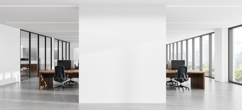 Modern office interior with blank wall poster mockup, desks, panoramic windows, and spacious architectural workspace for branding presentation. 3D Rendering