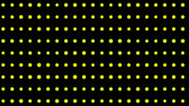 Uniformly spaced yellow circular lights forming a structured pattern on a dark surface