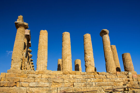  Agrigento, Italy - 08.22.2024: Ancient stone columns and archaeological remains standing against a vivid blue sky in the Valley of the Temples.
