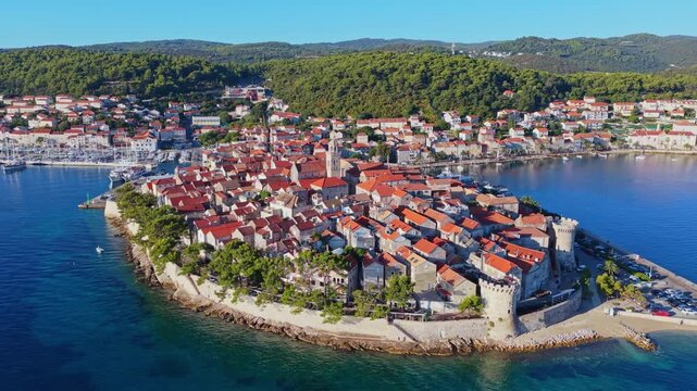 Aerial View of Historic Old Town Korcula with Red Tiled Roofs and Green Hills, Croatia