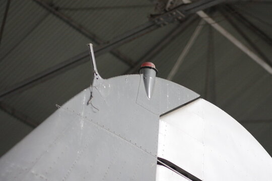 Close up of vintage airplane tail fin and vertical stabilizer inside a hangar