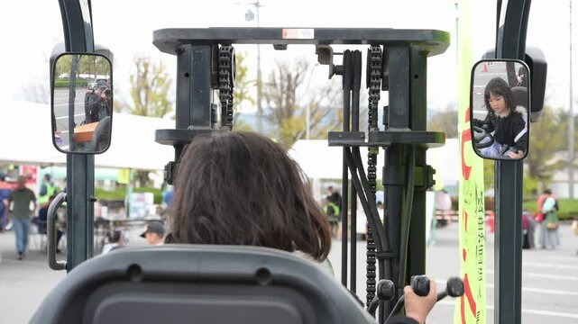 フォークリフトの運転席に座り操作を体験する女の子（はたらくくるま・イベント）