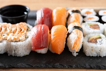 Assorted sushi platter with salmon, tuna, shrimp nigiri and maki rolls on wooden table © chandlervid85
