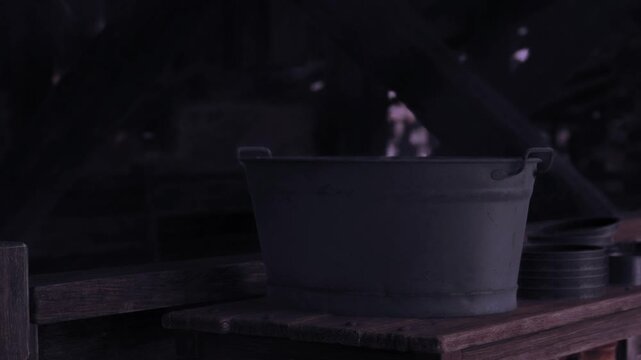Rustic tin buckets rest quietly on a weathered wooden table under soft light, creating a serene atmosphere that hints at past activities and stories told.