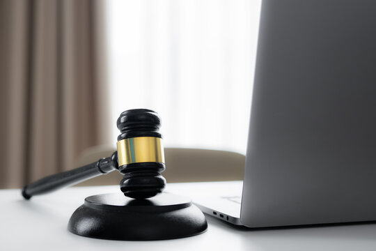 Judge gavel beside a laptop on a modern desk represents online legal services, digital law, court decisions, remote legal consultation, internet auctions and technology in the justice system.