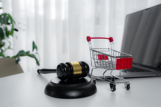 Judge gavel with shopping cart and laptop represents online auction, e-com law, consumer protection, digital marketplace regulation, legal purchasing, bidding disputes and internet commerce compliance
