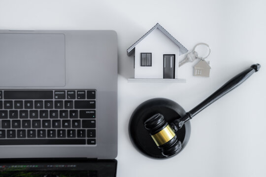 Judge gavel, house model, key and laptop symbolize property law, home ownership, real estate contracts, legal services, mortgage agreements and modern digital property transactions.