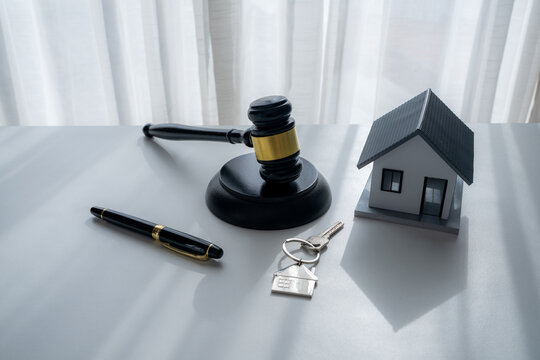 House model with judge gavel, home keys and pen symbolizes property rights, mortgage law, home ownership, real estate agreements, legal security and residential property transactions.
