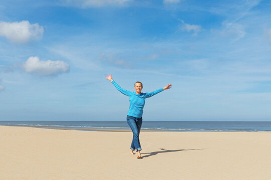 A carefree woman celebrates freedom and wellbeing on the beach