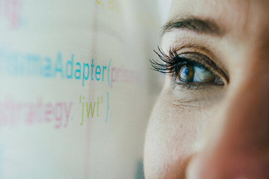 Businesswoman looking at computer code on a digital screen