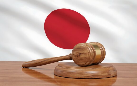 Wooden judge gavel resting on a table in front of the national flag of japan 2027
