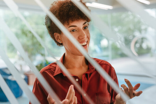 Smiling businesswoman talking behind a glass wall in the office
