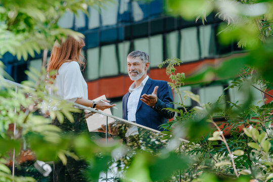 Businessman and businesswoman discuss work outdoors