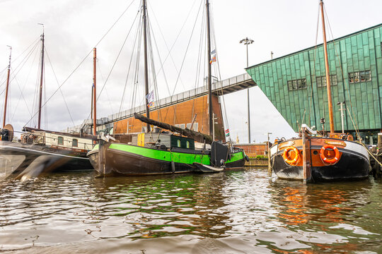 Boats Moored in a Harbor. Old ships on water. Amsterdam, Netherlands - 28 October 2025
