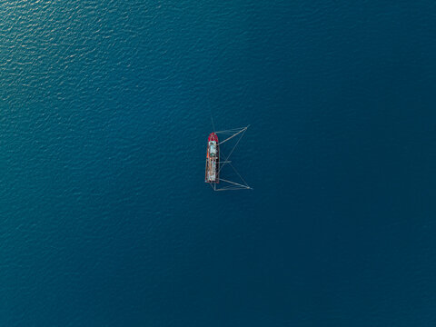 Aerial view of a fishing vessel kapal pukat floating in the deep blue sea in Karimunjawa, Central Java, Indonesia.