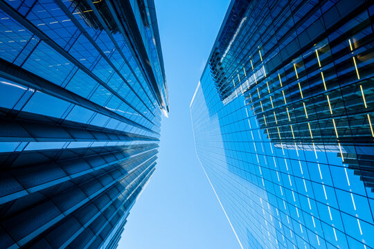 Modern urban architecture in London England with reflective glass towers vertical lines and sky seen in a perspective defined by towers and vertical architecture