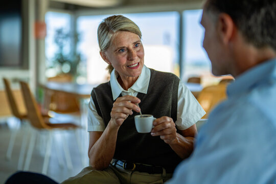 Businesswoman and businessman discuss a contract over coffee
