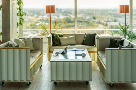 Sunny modern office lounge with mobile furniture and city view