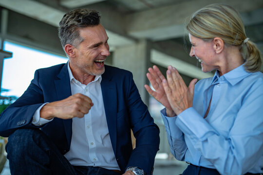 Two businesspeople celebrating success and teamwork in a start up