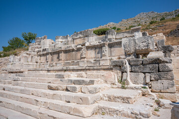 Stone reliefs decorate an ancient facade above steps at Sagalassos. Wide stone steps lead up to the decorated ruins © Ensar