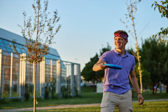 Young man playing frisbee in urban park