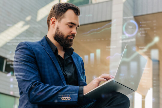 A businessman works on his laptop computer outdoors