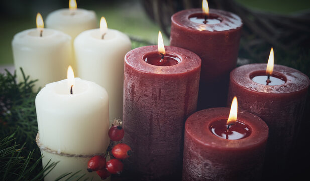 Burning red and white wax candles as a symbol of faith. Background for religious traditions and holidays. 
