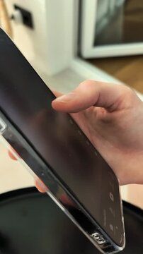 Doomscrolling social media feed application on vertical smartphone screen close up. Female person swiping digital video timeline interface continuously on high tech touch display. Internet