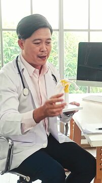Male doctor uses a shoulder joint model to explain anatomy and treatment in a bright clinic, representing healthcare, orthopedics, diagnosis, education, consultation and medical care.