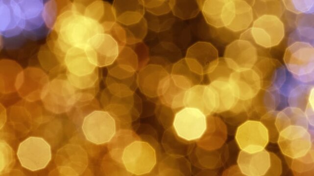 Abstract motion background with dynamic and festive golden bokeh lights creating a sparkling and blurred effect, perfect for holiday and celebration themes.