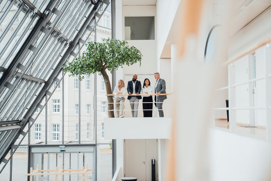 Business colleagues discuss a project on an office balcony