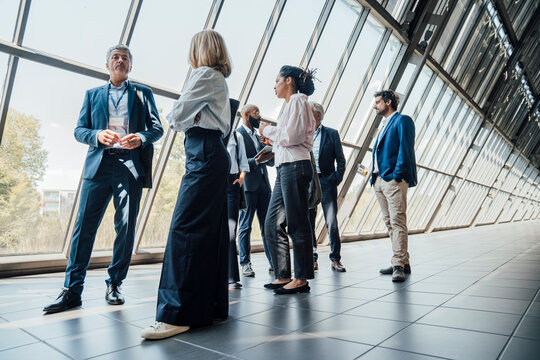 Colleagues converse inside a modern trade fair hall