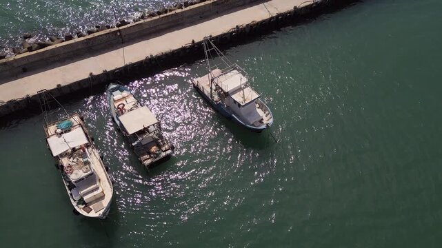 Aerial View of Fishing Boats Moored at Pier in Sparkling Sea