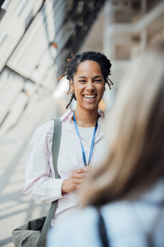 A happy businesswoman talks with a colleague at a trade fair