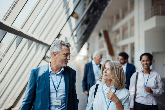 A businessman talks to a businesswoman at a trade fair