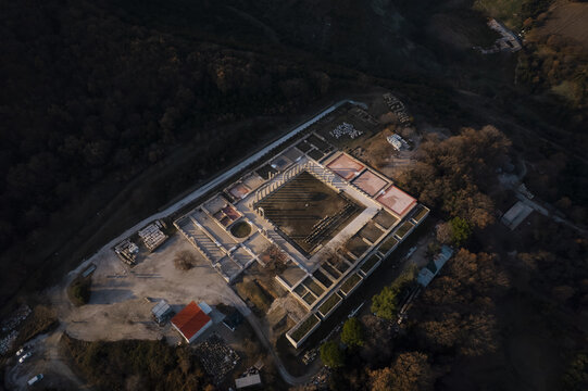 Aerial view of the ancient Temple of Apollo Epicurius at Bassae, featuring its iconic colonnades and rectangular layout surrounded by dense forest in Peloponnese, Greece.