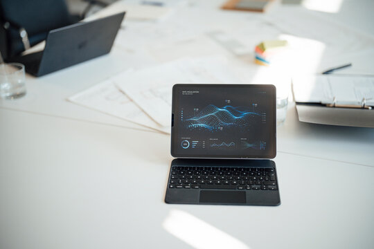 Tablet with data analysis on a desk in an empty meeting room