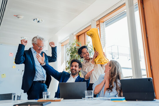 Business colleagues celebrate success with a balloon in the office