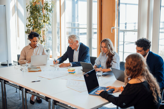 Businessmen and businesswomen collaborating in bright office