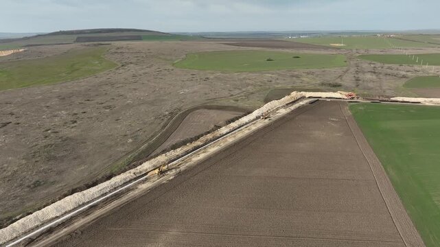 Aerial view of gas and oil pipeline construction. Pipes welded together. Big pipeline is under construction.