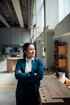 A confident businesswoman manages a sustainable carpentry workshop