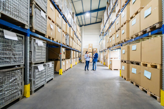 Man and woman plan logistics with a tablet in a warehouse