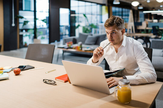 A businessman works on his laptop in a modern office