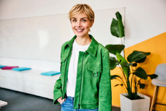 Smiling businesswoman stands in a modern office