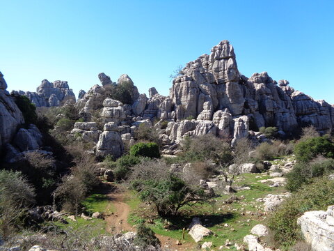 Dramatic limestone rock formations and hiking trail in El Torcal de Antequera, M&aacute;laga, Spain.