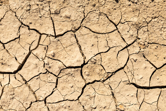 Sol en terre craquel&eacute;e par la s&eacute;cheresse, vue en gros plan de dessus 