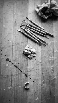 Professional sculpting and carving tools on a wooden work desk with sculpting modeling workshop instrument equipment creative monochrome overhead hardwood technical close-up implement