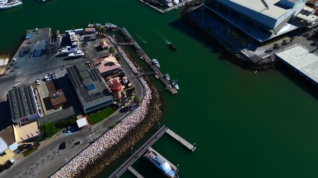 Top view from drone of sailboats and various speed boats in dock. Aerial view of luxure yachts and motorboats moored in a port with clear blue water in summer. Vilamoura, Algarve, Portugal